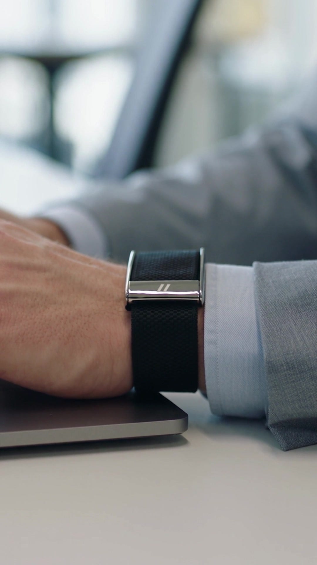 Strap under a shirt cuff at a desk